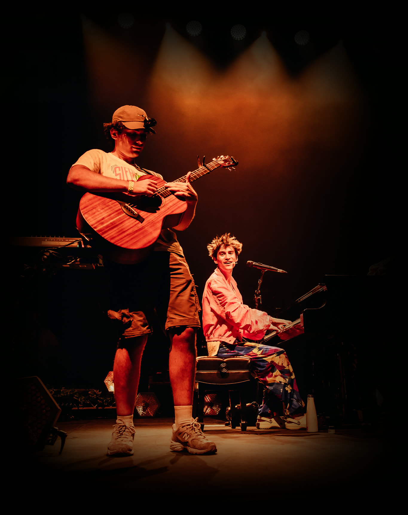 Mert Boyali playing guitar on stage at the ICC alongside Jacob Collier at the piano