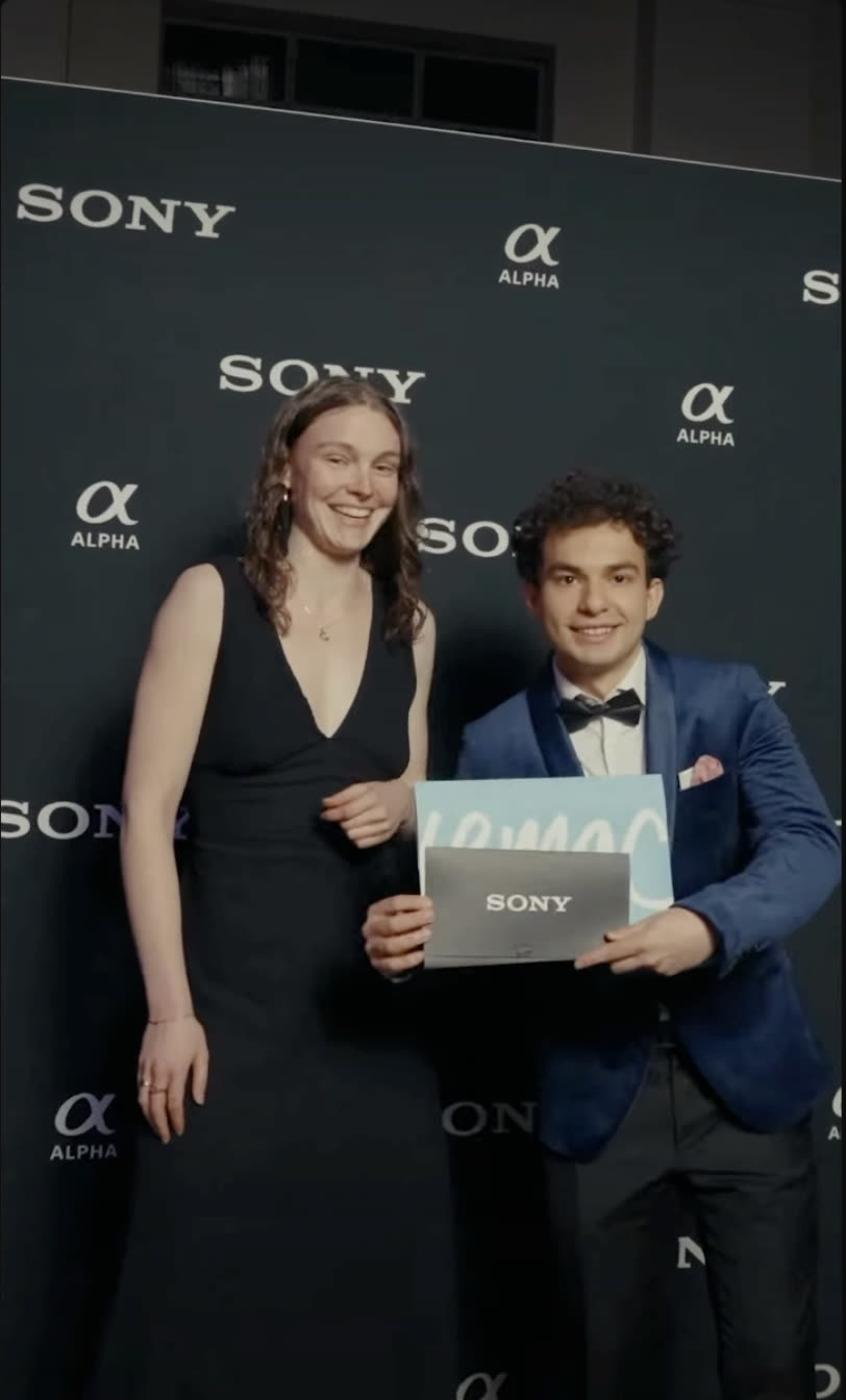 Mert Boyali holding an award on the media wall at the Sony Catchlight Film Festival